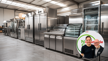 A row of commercial refrigeration equipment in the Nationwide Catering Equipment warehouse, including upright fridges, an undercounter prep counter, a curved-glass deli display and a glass-door bottle cooler.